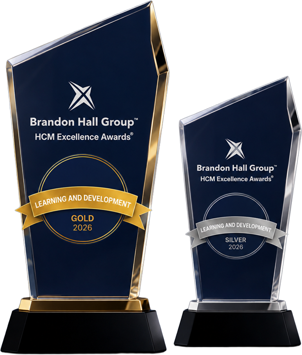 Two dark blue glass trophies with gold and silver accents, Brandon Hall Group HCM Excellence Awards 2026 for Learning and Development (Gold and Silver).